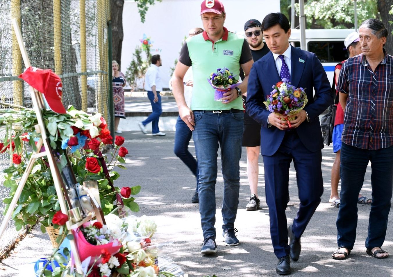 Казахстанцы несут цветы к месту трагедии, где был убит фигурист Денис Тен, в Алма-Ате