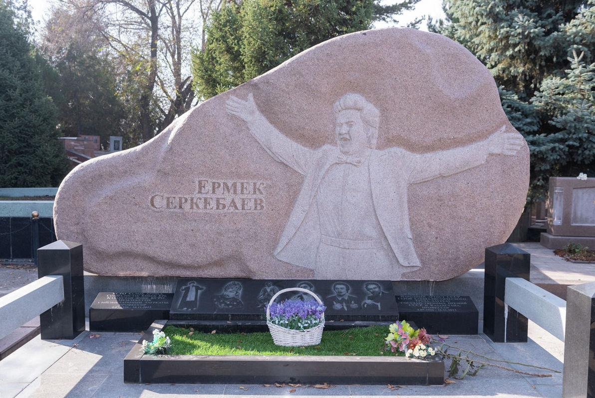 Оперный и камерный певец, актёр Ермек Серкебаев покоится под каменной стелой с собственным профилем-барельефом по центру