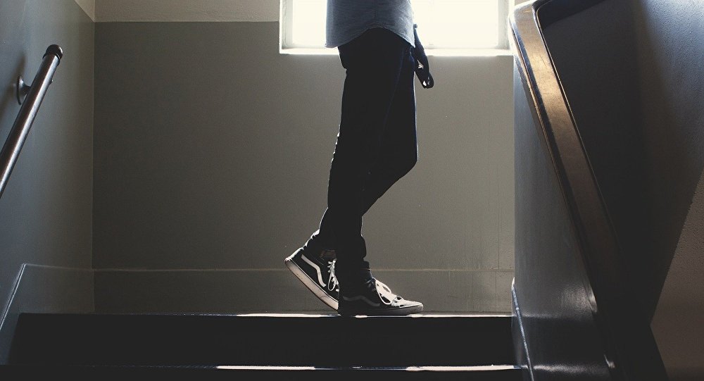 Мальчик стоит на лестнице
