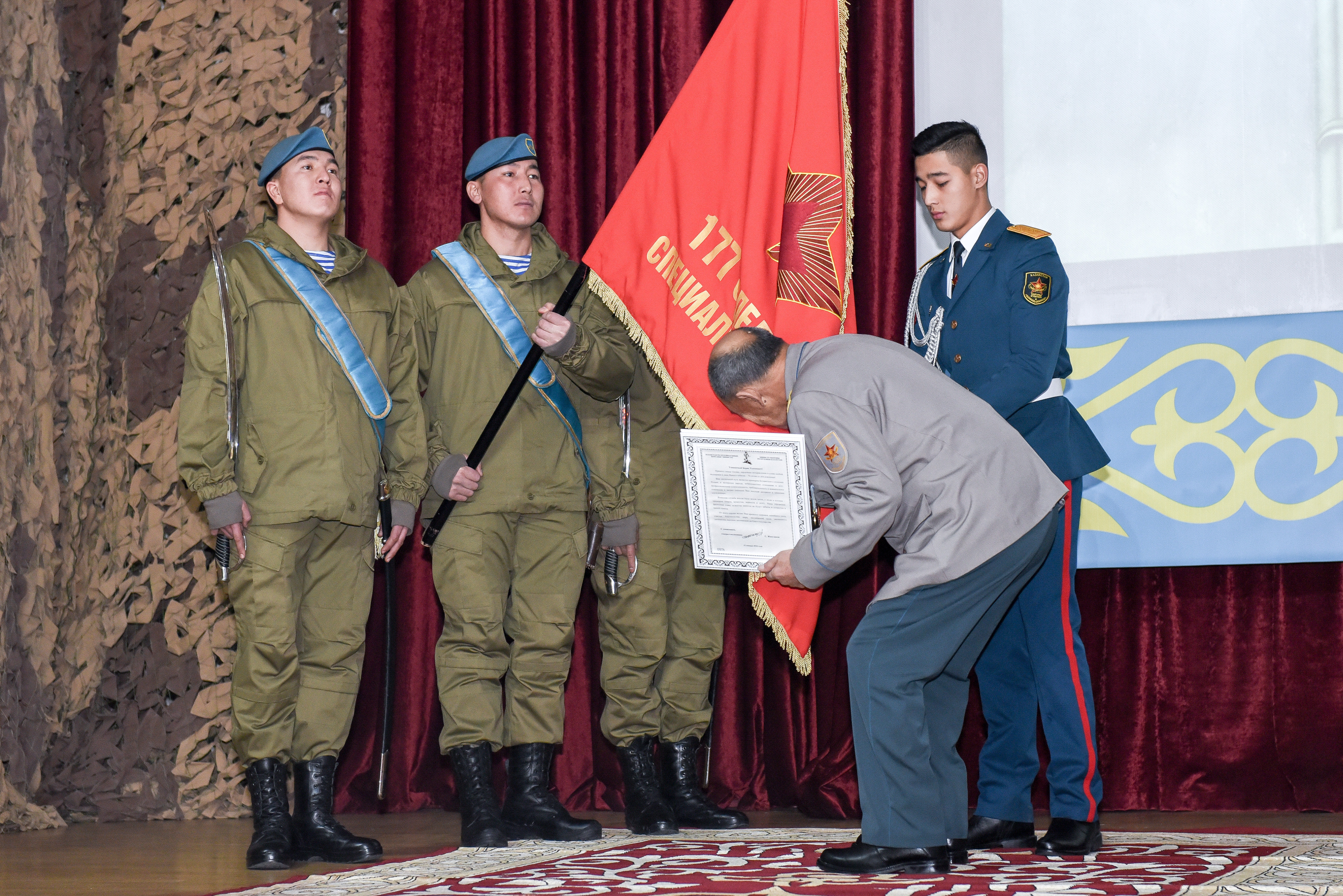 Борис Керимбаев целует знамя отряда спецназа